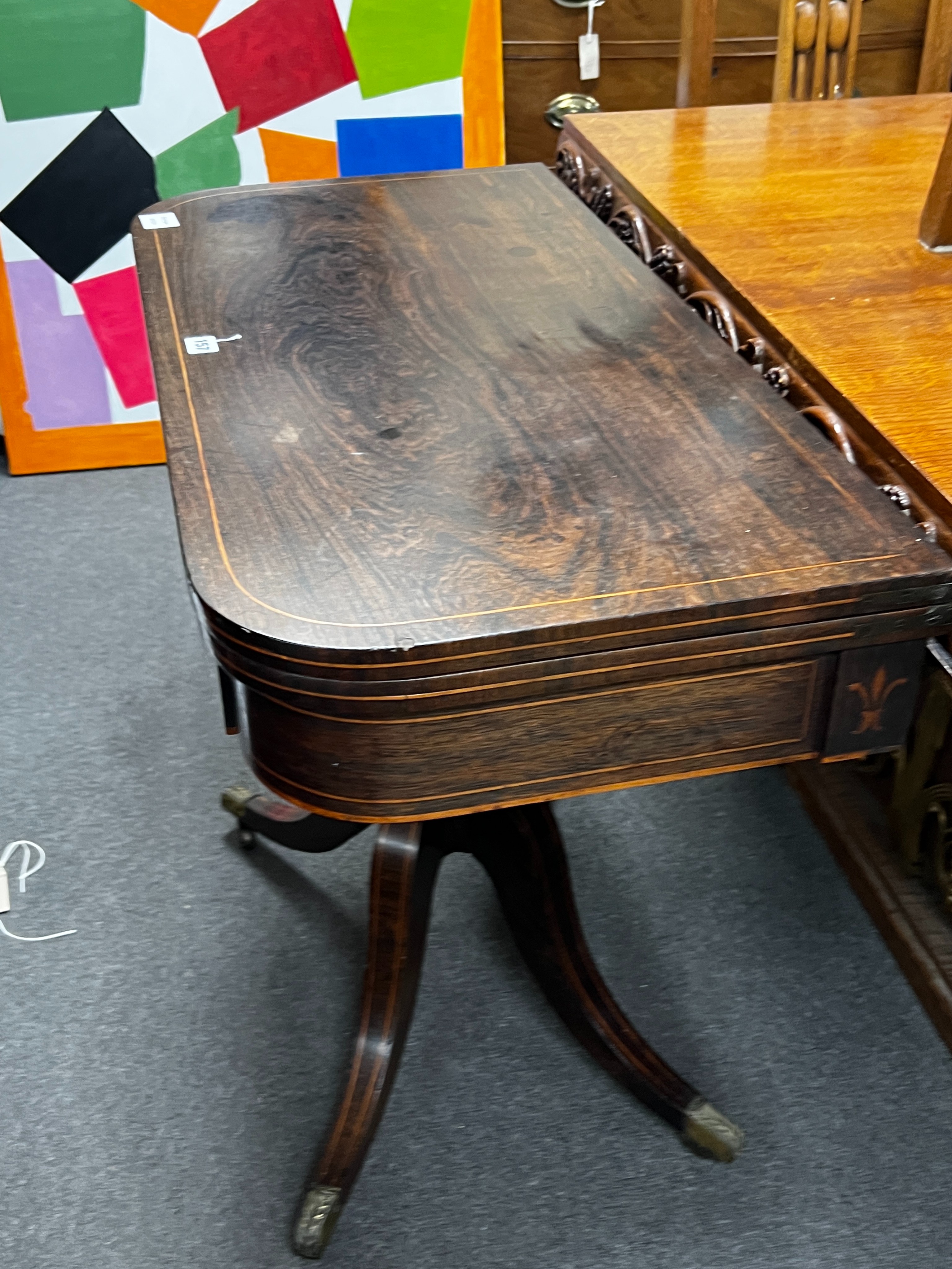 A Regency inlaid rosewood D shaped folding card table, width 86cm, depth 44cm, height 74cm